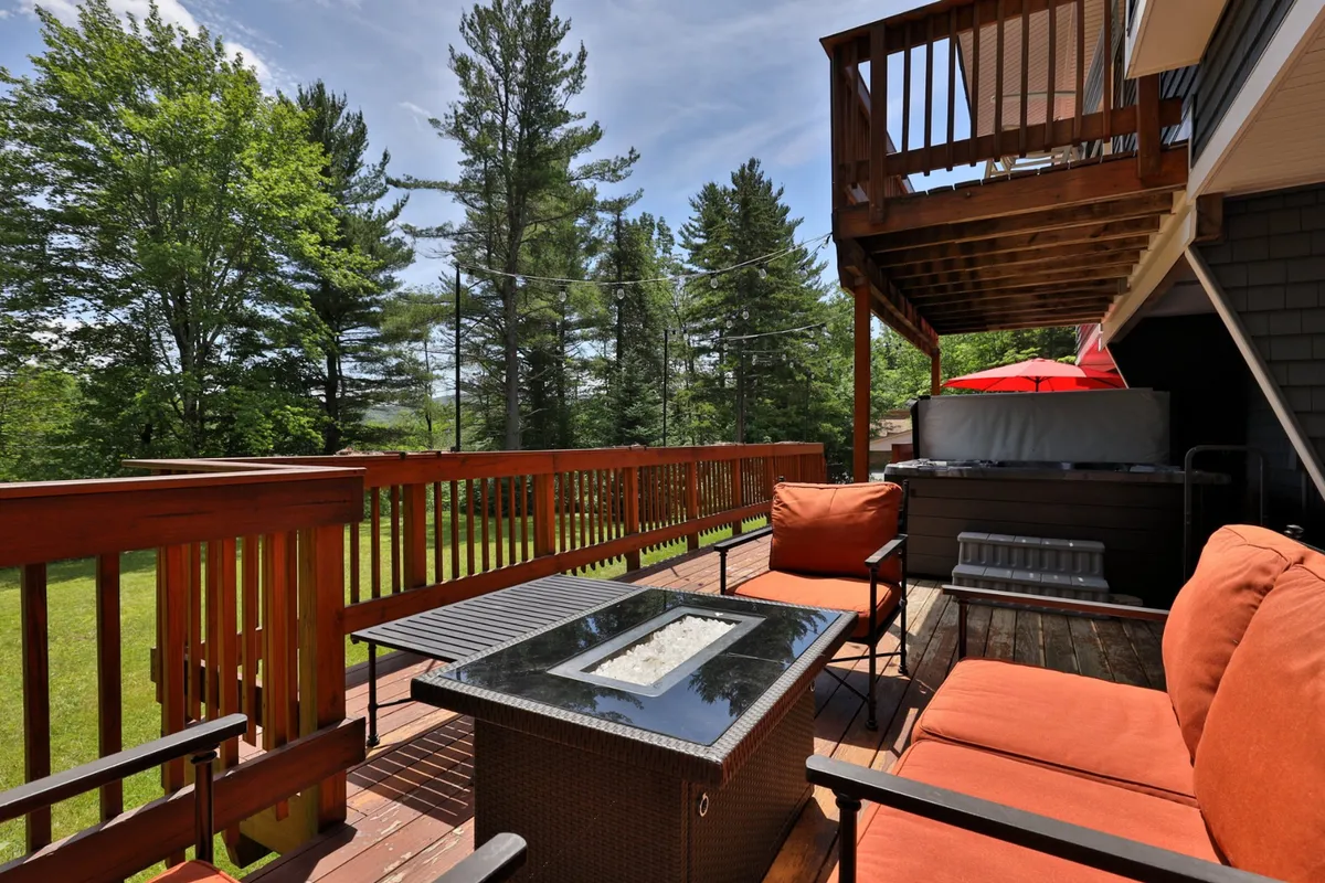 The scene centers on a welcoming outdoor seating area with a well-defined fire pit, surrounded by lush greenery. Comfortable chairs invite guests to gather, making it a perfect spot for sharing stories and roasting marshmallows under the stars.